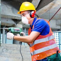 Worker wearing PPE drilling