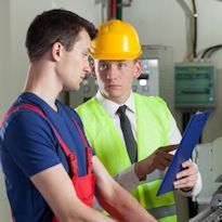 A supervisor asking an employee questions about the work he is doing