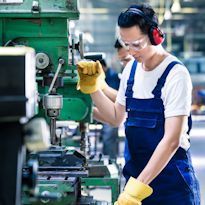 Worker wearing PPE operating a machine 