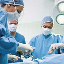 Healthcare workers wearing PPE while performing surgery
