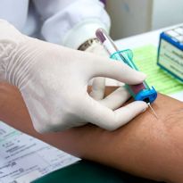 Nurse drawing blood from arm of patient