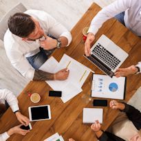 Two workers sitting at desk discussing a training plan