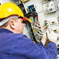 Electrician working at electrical panel