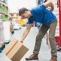 Warehouse worker bent over displaying low back pain