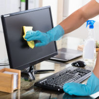 Worker with hand protection clearning computer screen