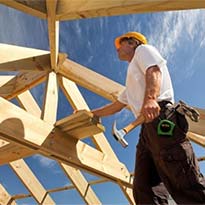 Construction worker nailing wood members