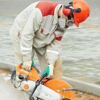 Worker cutting asphalt