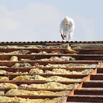 Construction worker working on insulation containing asbestos