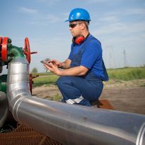 Worker taking meter readings along pipeline