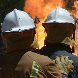 Image of firefighters approaching large fire.