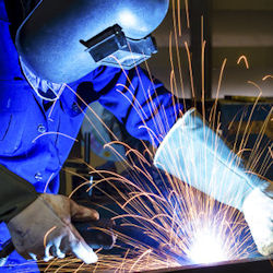 Image of an employee welding who would be aware of fire hazards.