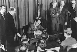 Former USA President Nixon signs the OSHAct into law in 1970. - public domain image.