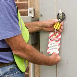 Worker tagging out an electrical panel.