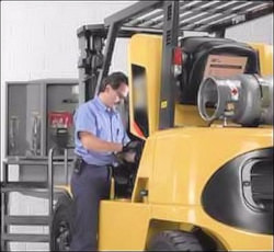 Man inspecting a forklift power source