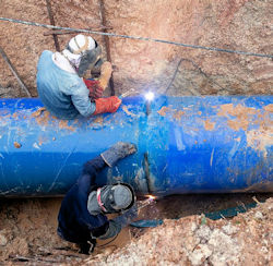 Welders working in trench