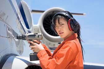 Worker using drill at elevated height