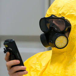 Worker wearing PPE while testing for hazardous atmospheres