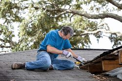 A person on roof performing an inspection.