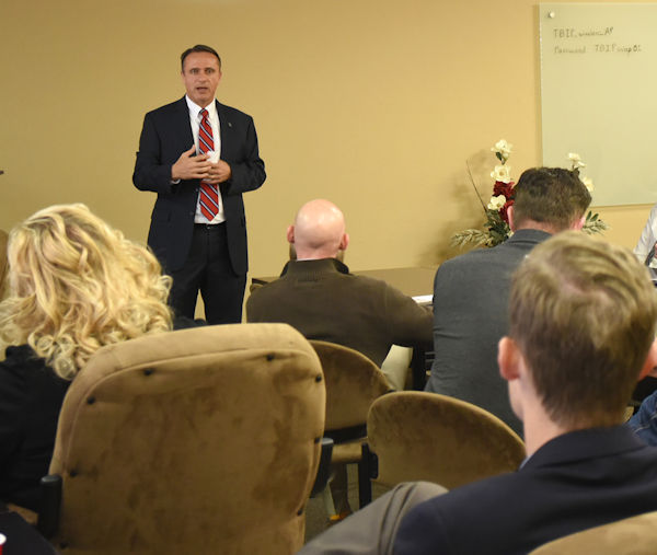 Person speaking in front of a group of people.