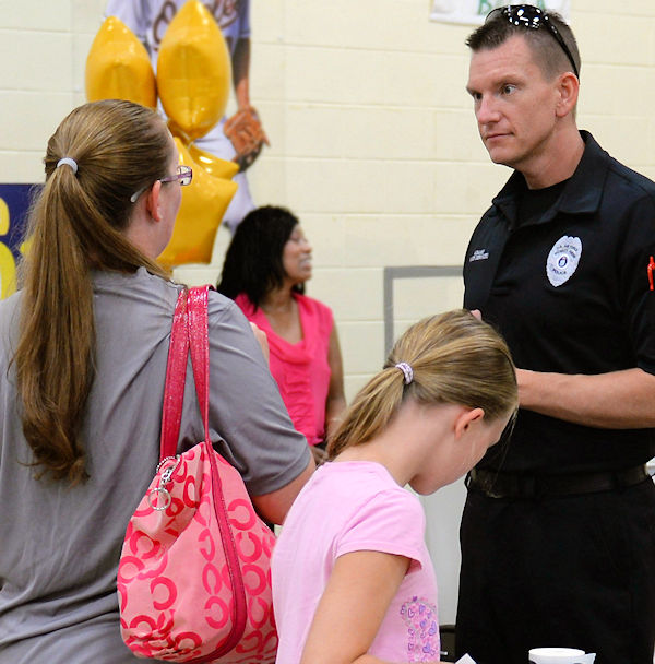 police officer speaking with parent while child stands by