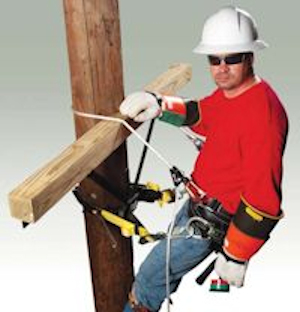 Electrician on pole in PPE with fall protection