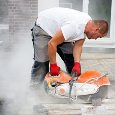 Employee cutting cement with no PPE and silica in the air.