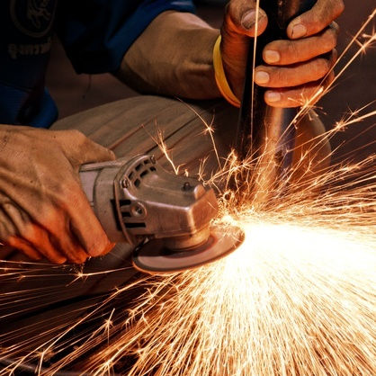 A worker grinding metal.