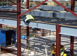 A worker on a beam 20 feet in the air with no fall protection.