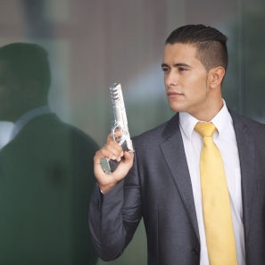 A man indoors carrying a gun.
