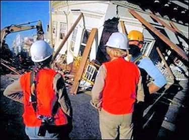 Employees with hard hats and vests looking at an accident seen.