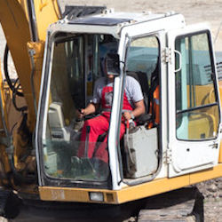 A worker in the cab of heavy equipment 