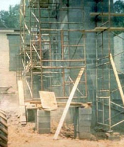Scaffold raised improperly. Base of scaffold placed on cement blocks that are stacked six high.