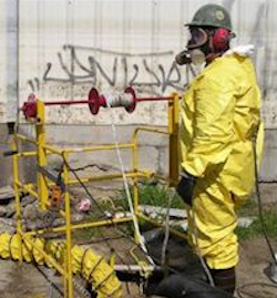Confined space attendent, wearing a respirator and hazmat suit.