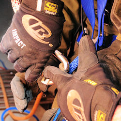Confined space team member receiving training for set up of fall harness.