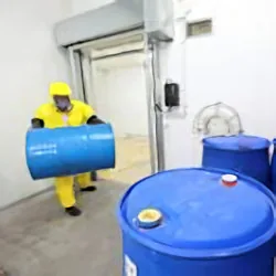 Worker covered with PPE moving one container over to two other containers