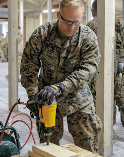 construction worker performing nail gun training on scrap wood