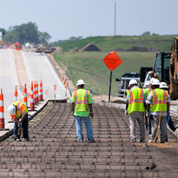 Workers preparing a road to have cement poured.