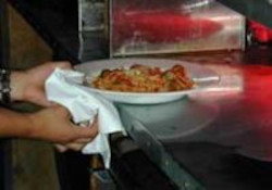 Server using towel to carry hot plate.