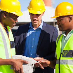Three contractors discussing blueprints