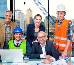 Employees working together in front of a laptop.