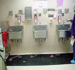 Three wall mounted sinks with touch free soap dispensers