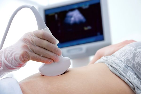 Ultrasound tech conducting ultrasound on a patient.