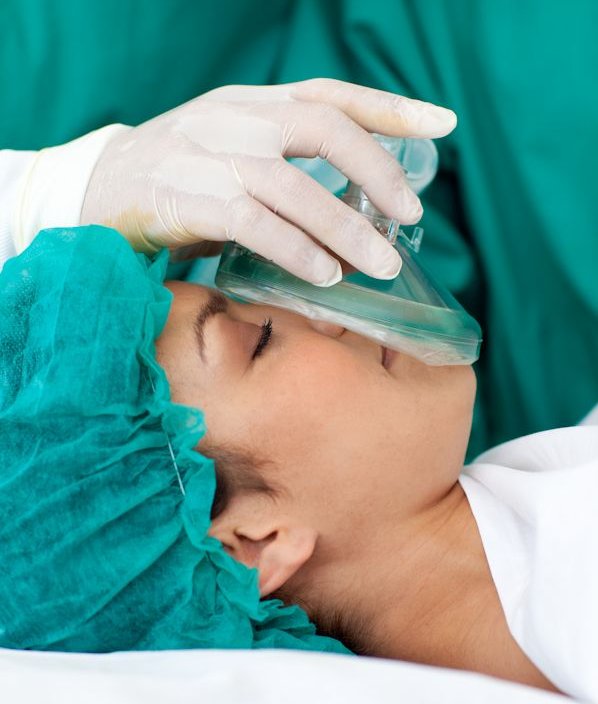 Patient having a anesthetic mask placed over face.