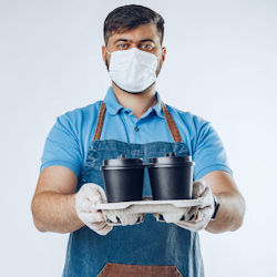 Worker with mask and gloves delivering coffee drinks