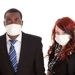 A man and a woman in suits wearing face masks.