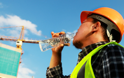 Worker in PPE standing near a radiant heat barrier