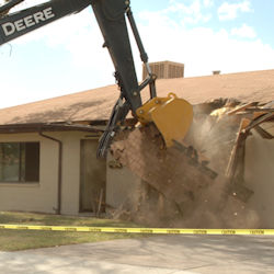 front end loader demolishing a house
