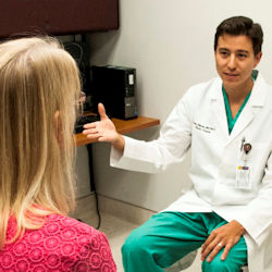 Doctor speaking to patient in a an exam room.