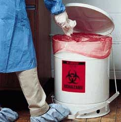 Healthcare provider placing a contaminated tissue into a biohazard can.