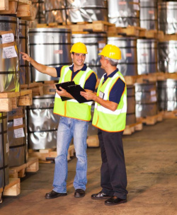 Two workers in a warehouse performing an initial assessment of chemicals